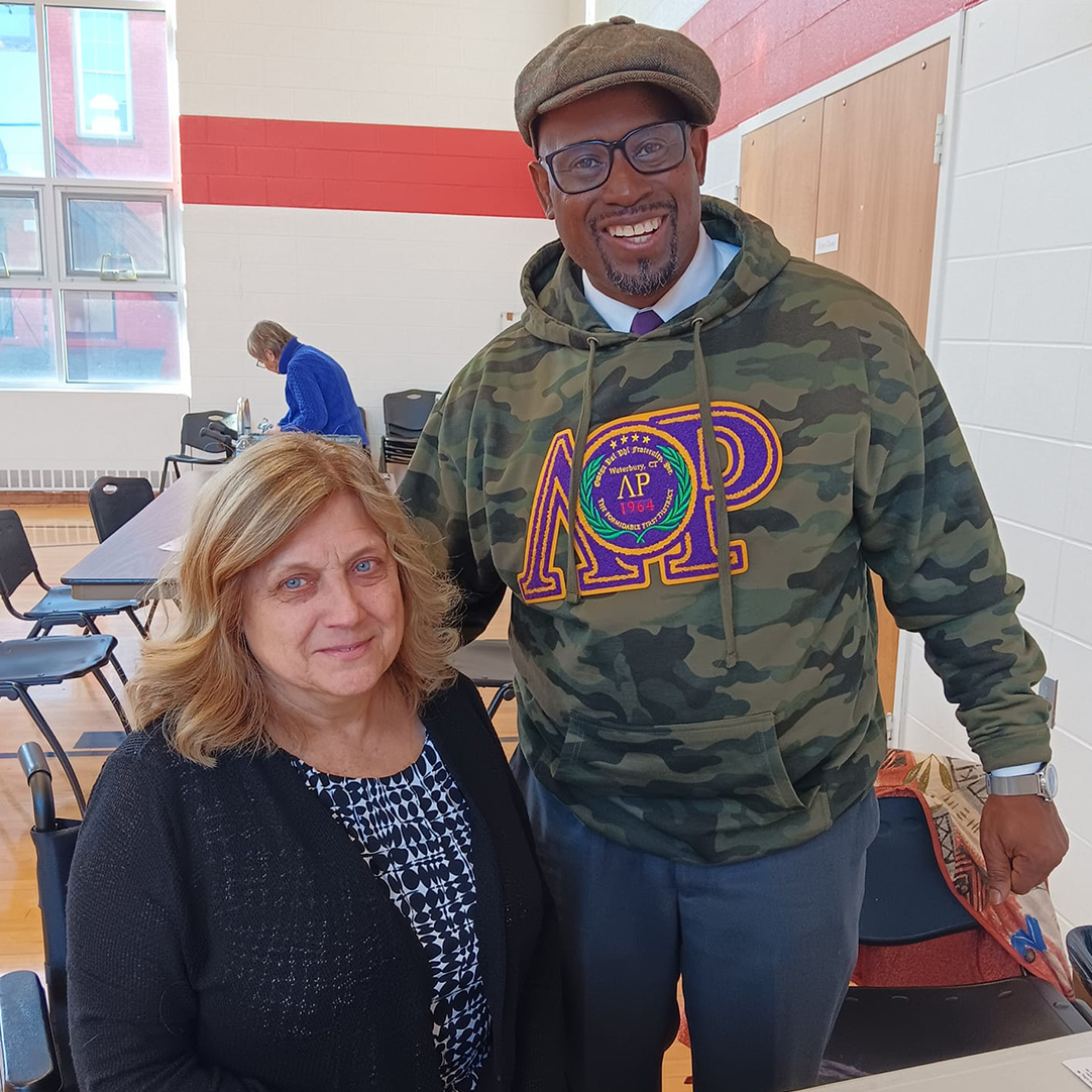 Two board members standing in a gymnasium.