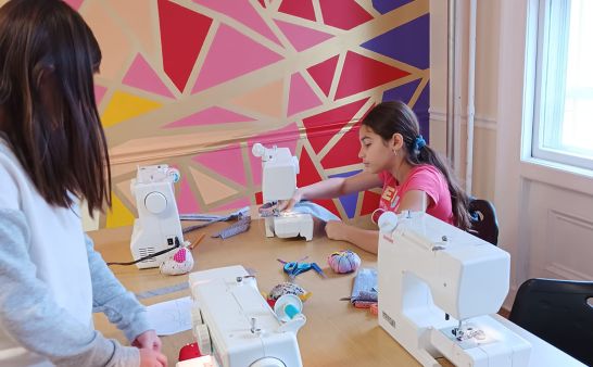 Two girls working with sewing machines.